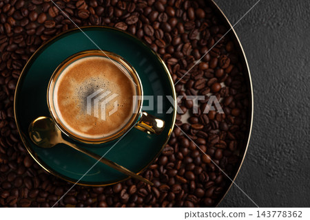 Fresh espresso in a green cup surrounded by coffee beans Fresh espresso in a green cup surrounded by coffee beans 143778362