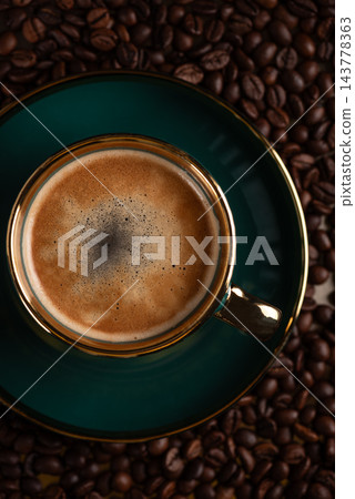 Fresh espresso cup with crema on coffee beans background Fresh espresso cup with crema on coffee beans background 143778363