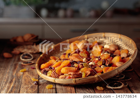Assorted nuts and dried fruits in wooden dish. Assorted nuts and dried fruits in wooden dish. 143778634