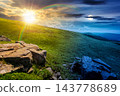 Carpathian mountain on summer solstice landscape. day meet night. sun and moon over meadow with huge stones among the grass on top of the hillside near the peak of mountain range at twilight 143778689