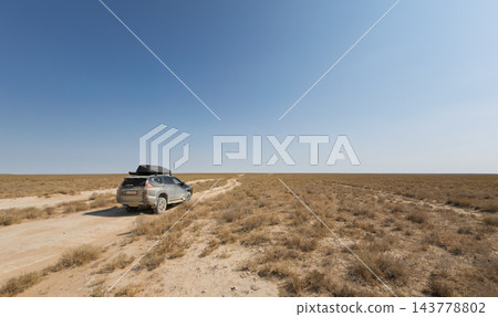 一輛四輪傳動車沿著曼格斯套塵土飛揚的道路行駛。 一輛四輪傳動車沿著曼格斯套塵土飛揚的道路行駛。 143778802