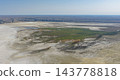 The lush green oasis of Onere, surrounded by white salt flats of the desert. 143778818