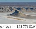 The isolated hill of Karinjarik casts its shadow over the salt flats. 143778819