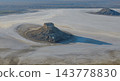A long shadow stretches behind the isolated hill of Karinjarik 143778830