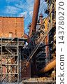 Vertical photo of historic blast furnace steel framework with brick building housing massive rusty gas pipeline skip hoist bridge and stairs in Duisburg Ruhr region Westphalia Germany 143780270