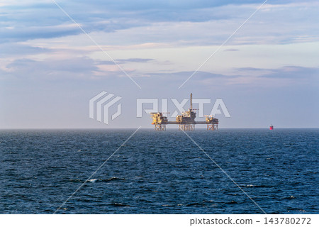 Offshore platform on calm sea under pastel sky 143780272