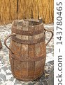 Antique rustic wooden barrel with rusted iron hoops and handles 143780465