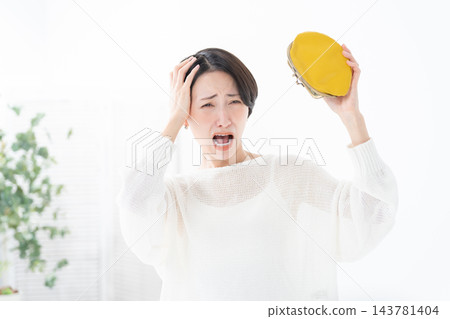 A woman worried about money, carrying a coin purse. A woman worried about money, carrying a coin purse. 143781404