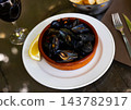 Closeup of deliciously appetizing steamed mussel with lemon on clay plate 143782917