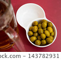 Green olives with pits served in bowl 143782931