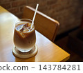 畫面中有一張木桌和一杯冰拿鐵。 143784281