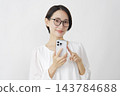中年婦女使用智慧型手機；白色背景；肖像；直視鏡頭。 143784688