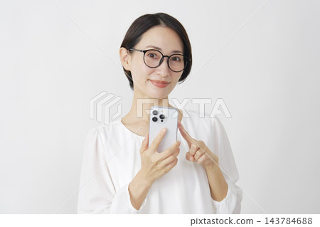 中年婦女使用智慧型手機；白色背景；肖像；直視鏡頭。 143784688