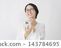 一位中年婦女在白色背景下使用智慧型手機進行想像。 143784695