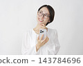 一位中年婦女在白色背景下使用智慧型手機進行想像。 143784696