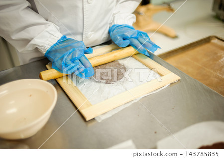 用擀麵杖擀麵團的過程;糕點師用尺確保麵團厚度均勻;西式糕點製造;糕點製作過程。 用擀麵杖擀麵團的過程;糕點師用尺確保麵團厚度均勻;西式糕點製造;糕點製作過程。 143785835