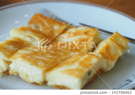 Slices of freshly baked cheese turkish borek pastry, neatly arranged and served on a plate Slices of freshly baked cheese turkish borek pastry, neatly arranged and served on a plate 143786062