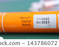 Orange insulin syringe barrel showing manufacturing, expiry, and batch label 143786072