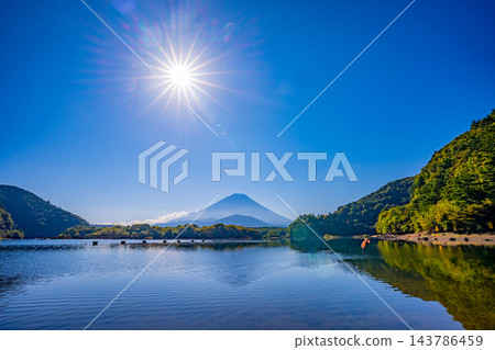 [Yamanashi Prefecture] Mount Fuji visible beyond the windless surface of Lake Shoji in autumn. 143786459