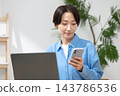 一位女士在客廳使用電腦 143786536