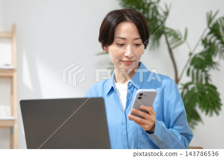 一位女士在客廳使用電腦 143786536