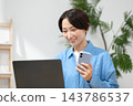 一位女士在客廳使用電腦 143786537