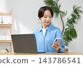 一位女士在客廳使用電腦 143786541