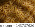 Commercial food photography of a top-down background of dry fusilli pasta with moody shadows 143787620
