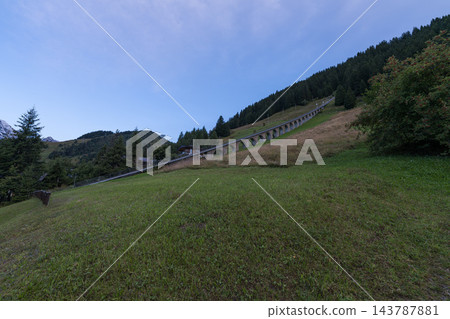 一座石砌高架橋蜿蜒穿過綠色的山坡。 143787881