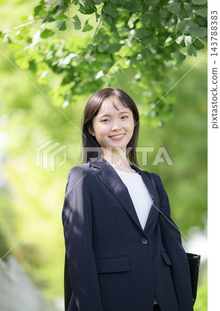 一位年輕的日本女員工,剛畢業不久,在美麗的春日綠蔭下方帶著微笑,直視鏡頭,展現了大學生求職或新進員工的形象。 一位年輕的日本女員工,剛畢業不久,在美麗的春日綠蔭下方帶著微笑,直視鏡頭,展現了大學生求職或新進員工的形象。 143788383