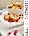 Berry pastry. Baked treats. Golden biscotti served on white rustic ceramic plate with cranberries. Dried sweet bread piece background. 143790330