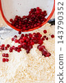 Berry pastry preparation. Baking cookies. Pouring red cranberry from bowl in flour crumbs pile making sweet treat with natural flavor. 143790352