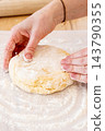 Pastry making. Home cooking. Female baker hand kneading dough piece on flour kitchen counter. Wheat ingredient for tasty baking food. 143790355