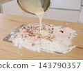 Berry pastry preparation. Baking cookies. Pouring liquid batter from bowl in flour crumbs cranberry pile on wooden table making sweet treat. 143790357