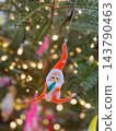 Tiny Christmas ornaments swaying in the light 143790463
