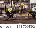 The back view of a parking enforcement officer crossing an intersection 143790592
