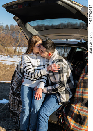 Young Couple Embracing Under Blanket During Winter Road Trip Young Couple Embracing Under Blanket During Winter Road Trip 143790615