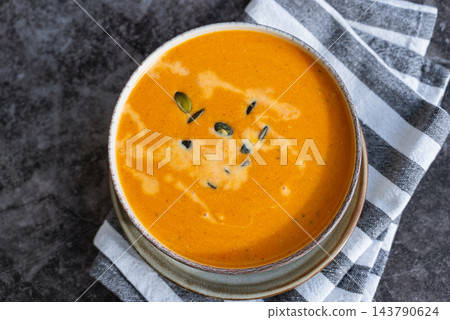 Smooth texture natural colors and fresh dairy contrast beautifully with the garnish of Creamy Pumpkin Soup Garnished with Pumpkin Seeds. Concept of homemade cooking seasonal ingredients Smooth texture natural colors and fresh dairy contrast beautifully with the garnish of Creamy Pumpkin Soup Garnished with Pumpkin Seeds. Concept of homemade cooking seasonal ingredients 143790624