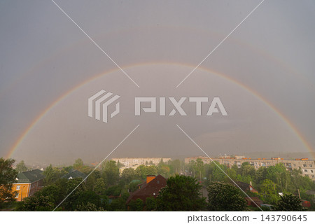 Weather conditions light interaction and beauty of nature. Soft daylight illuminates the clouds and enhances the vivid rainbow arc. Concept of hope optimism tranquility meteorology climate, and 143790645