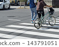 A young couple crossing a pedestrian crossing at an intersection. 143791051