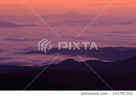 黎明時分,山脈漂浮在雲海之中。 黎明時分,山脈漂浮在雲海之中。 143791302