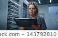 Female IT Specialist Analyzing Changing Server Metrics and Possible System Issues 143792810