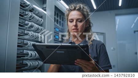 Female IT Specialist Analyzing Changing Server Metrics and Possible System Issues Female IT Specialist Analyzing Changing Server Metrics and Possible System Issues 143792810