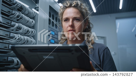 Female IT Specialist Analyzing Changing Server Metrics and Possible System Issues Female IT Specialist Analyzing Changing Server Metrics and Possible System Issues 143792827