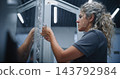 Female IT Specialist Installing Network Cables Inside Modern Server Equipment 143792984