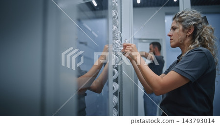 IT Technicians Connecting Network Cables to Separate Server Racks in Data Center 143793014