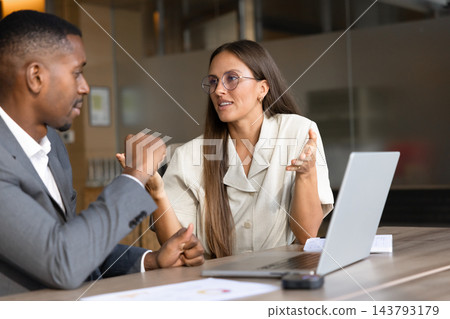 Multiethnic colleagues discussing business strategy in office Multiethnic colleagues discussing business strategy in office 143793179