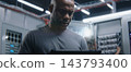 Male IT Specialist Standing in Modern Server Room with Digital Tablet 143793400