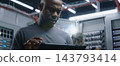 Male IT Manager Consulting Female Network Technician While Female Tests Ethernet Connections 143793414