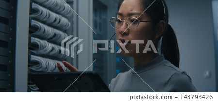 IT Technician Wearing Headset and Reviewing Network Connections on Tablet IT Technician Wearing Headset and Reviewing Network Connections on Tablet 143793426